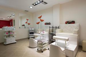 a hair salon with white chairs and a mirror at Porto Galini Seaside Resort & Spa in Nikiana