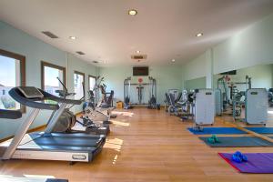 a gym with a bunch of treadms and cardio machines at Porto Galini Seaside Resort & Spa in Nikiana
