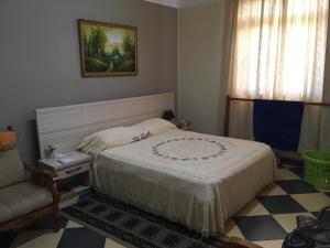 a bedroom with a bed and a chair and a window at Br Court Apartments in Quatre Bornes