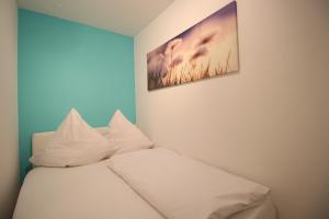 ガルミッシュ・パルテンキルヒェンにあるPearl Royaleの白い枕と壁画付きのベッド