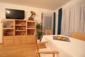 ein Wohnzimmer mit einem Tisch und einem TV in der Unterkunft Pearl Royale in Garmisch-Partenkirchen