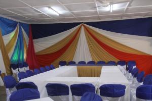 a circus tent with a table and blue chairs at Sheywe Hotel Kakamega in Kakamega