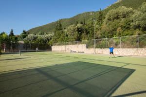 two people playing tennis on a tennis court at Porto Galini Seaside Resort & Spa in Nikiana