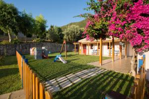 a yard with a playground and a house at Porto Galini Seaside Resort & Spa in Nikiana