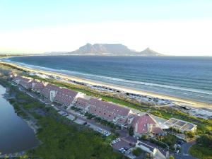 an aerial view of a beach with houses and the ocean at Dolphin Beach Hotel Self Catering Apartments in Bloubergstrand