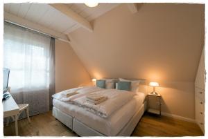 a bedroom with a large white bed with a window at Ferienhaus Flieder in Liepe in Rankwitz