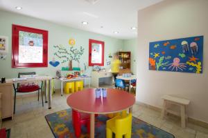a childs room with a table and chairs in it at Porto Galini Seaside Resort & Spa in Nikiana