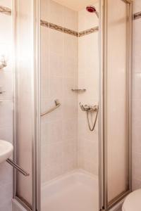 a shower with a glass door in a bathroom at Rumpenerhof in Brunssum