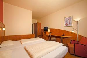 a hotel room with two beds and a desk at 1, 2, sleep Boardinghouse Unterschleißheim Zentrum in Unterschleißheim +18 photos