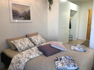 a bed with pillows on it in a room at Lahti City Home in Lahti