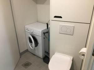 a small bathroom with a washing machine and a toilet at Lahti City Home in Lahti