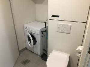 a small bathroom with a washing machine and a toilet at Lahti City Home in Lahti