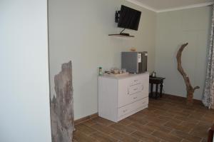 a living room with a tv and a white dresser at Kamaku Guesthouse in Otjiwarongo