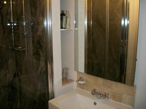 y baño con lavabo, ducha y espejo. en Middletown Farmhouse B&B en Okehampton