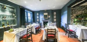 a dining room with tables and chairs and a fireplace at The Traddock in Austwick