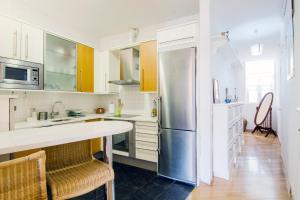a kitchen with white cabinets and a stainless steel refrigerator at Imperial, 6 in Madrid