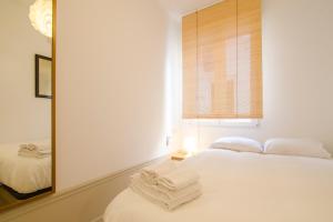 マドリードにあるValverde Apartmentのベッドルーム(白いベッド1台、鏡付)