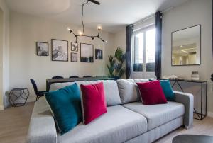 a living room with a gray couch with colorful pillows at Minty Stay - 3 BD Lavapies in Madrid