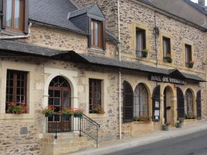 an old stone building with flowers in the windows at Hotel des Voyageurs in Payzac