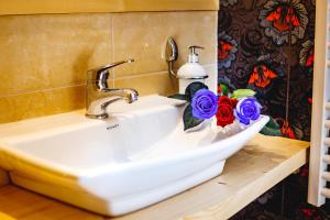 a sink in a bathroom with flowers on a counter at Willa Dorula in Małe Ciche +64 photos