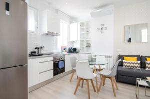 uma cozinha e sala de estar com mesa e cadeiras em Minty Stay - Jose Ortega y Gasset em Madri