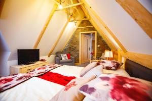 a attic bedroom with a bed and a tv at Willa Dorula in Małe Ciche