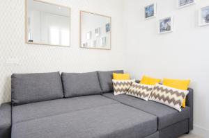 um sofá cinzento com almofadas numa sala de estar em Minty Stay - Jose Ortega y Gasset em Madri