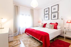 sypialnia z dużym białym łóżkiem z czerwonym kocem w obiekcie Huertas, 58 w Madrycie