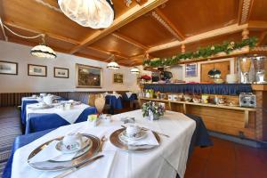 a restaurant with two tables with plates and utensils at Chambres Mont Cervin in Breuil-Cervinia