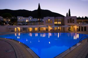 a large swimming pool in front of a building at Porto Galini Seaside Resort & Spa in Nikiana
