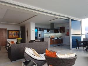 a living room with a couch and chairs and a kitchen at Amplio 140m2 Grand Diamond Tonsupa in Tonsupa