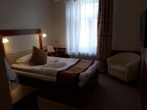 Un pat sau paturi într-o cameră la Hotel Tisza és Thermálfürdő