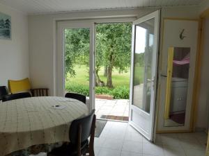 a dining room with a table and a sliding glass door at La maison dans le pré in Agon Coutainville