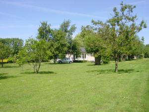 a yard with trees and a car parked in it at La maison dans le pré in Agon Coutainville