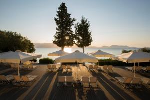 a group of tables and chairs with umbrellas at Porto Galini Seaside Resort & Spa in Nikiana