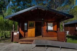 Cabaña de madera con porche y terraza en Camping & Bungalows Ligüerre de Cinca, en Ligüerre de Cinca