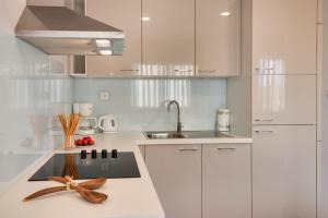 a white kitchen with white cabinets and a sink at Croatica Suites Brodarica in Brodarica +95 photos