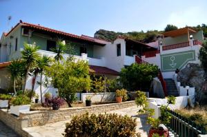 a house with a garden in front of it at Katina Balos Rooms-Studios in Koumeika