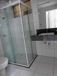 a bathroom with a glass shower and a toilet at Hotel Rodrigues in Garanhuns