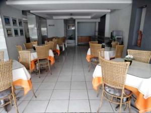 a dining room with tables and chairs in a restaurant at Hotel Rodrigues in Garanhuns