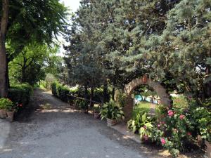 un jardín con un arco con flores y plantas en Belvilla by OYO Casale le Capanne, en Cortona