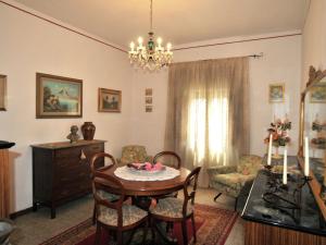 sala de estar con mesa, sillas y lámpara de araña en Belvilla by OYO Casale le Capanne, en Cortona