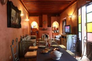 a dining room with a table and a fireplace at Riad Alwane in Marrakech