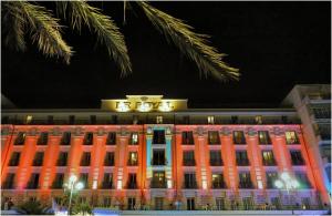a building with a clock on top of it at night at Hôtel Le Royal Promenade des Anglais in Nice