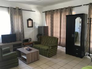 a living room with a couch and a television at Rest Assured Guest House & Conference Kokstad in Kokstad