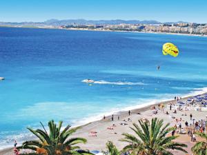 a group of people on a beach flying kites at Hôtel Le Royal Promenade des Anglais in Nice