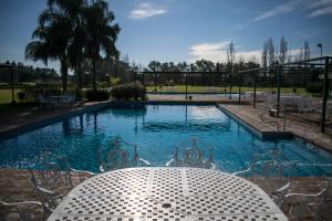 a pool with a table and chairs in front of it at San Ceferino Hotel & Spa in Open Door