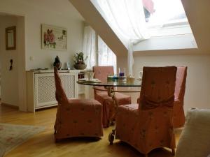ein Esszimmer mit einem Tisch, Stühlen und einem Dachfenster in der Unterkunft Alpenflair Ferienwohnungen Whg 214 "Schanzenblick" in Oberstdorf