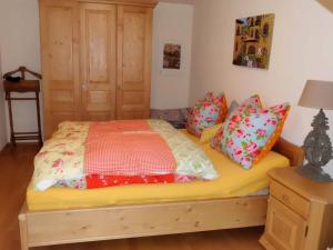 ein Schlafzimmer mit einem Bett mit bunten Kissen in der Unterkunft Alpenflair Ferienwohnungen Whg 214 "Schanzenblick" in Oberstdorf