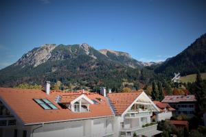 eine Gruppe von Gebäuden mit Bergen im Hintergrund in der Unterkunft Alpenflair Ferienwohnungen Whg 214 "Schanzenblick" in Oberstdorf